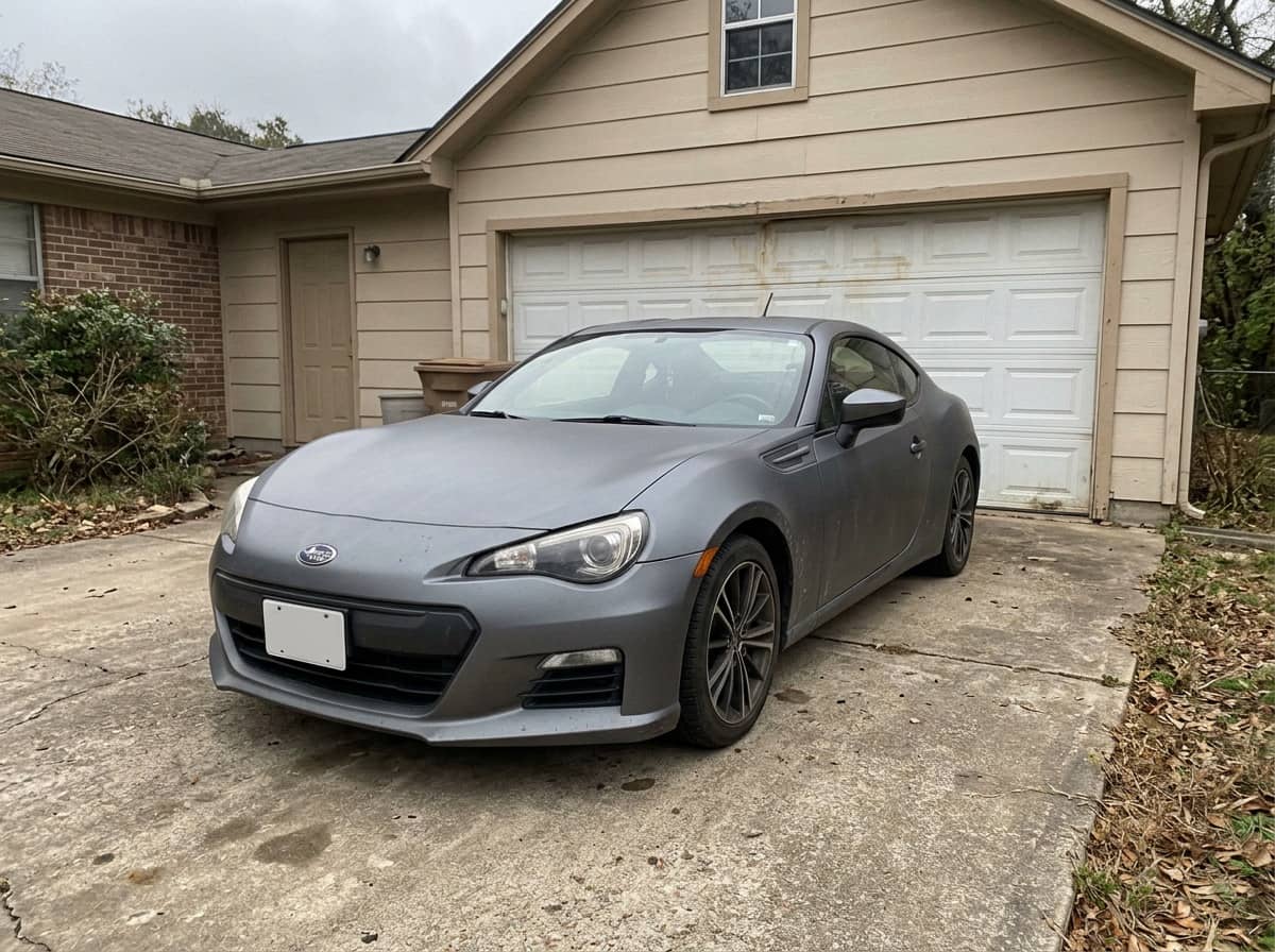 Phone photo of a customer sports car parked on a driveway